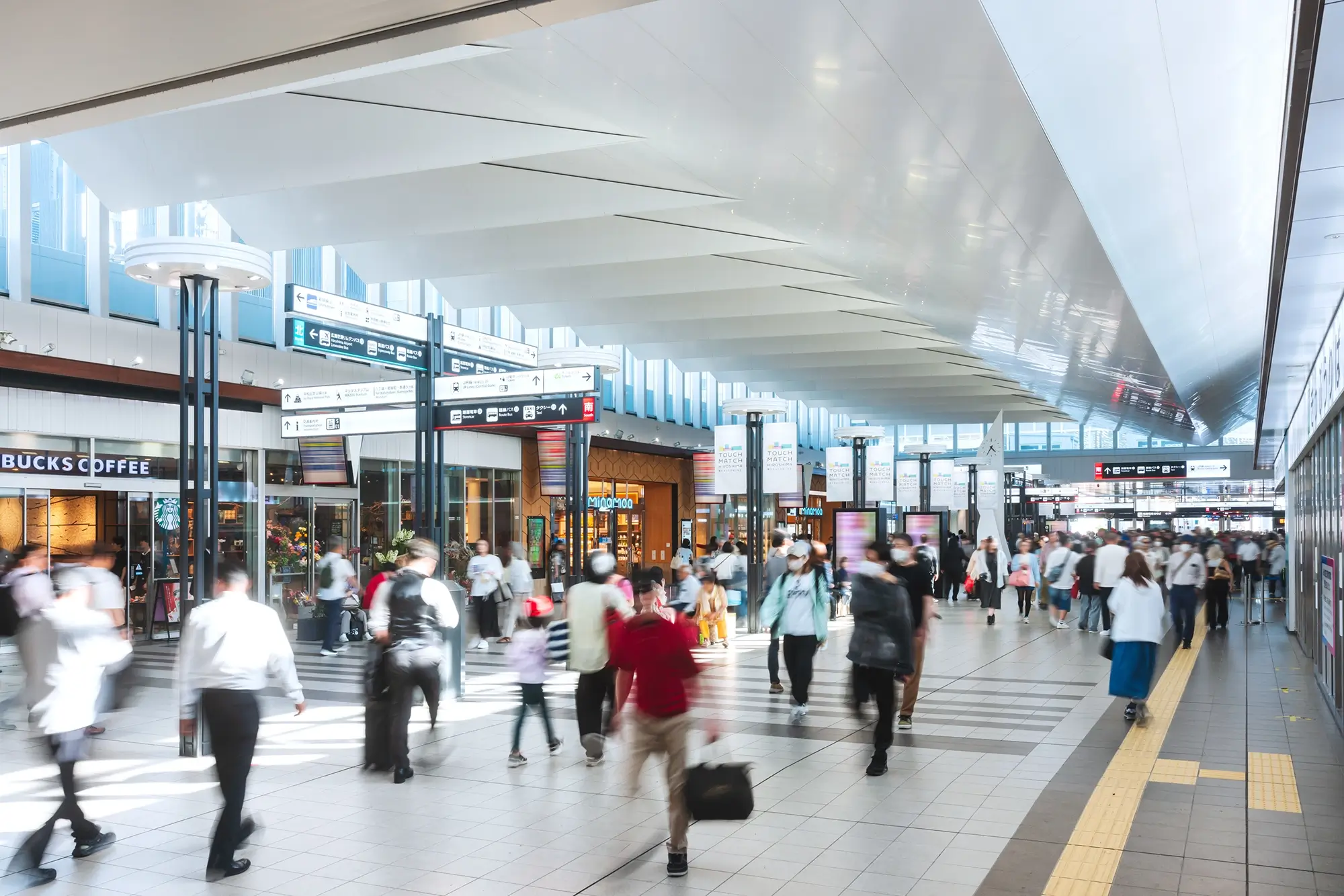天井のデザインが特徴的な広島駅の自由通路を、多くの人々が行き交う様子